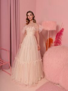 Style #826, shimmering tulle ball gown with ruffled off-the-shoulder neckline and tiered skirt; available in peach (shown online), blue, powder, pink, cornflower blue, green, red, turquoise