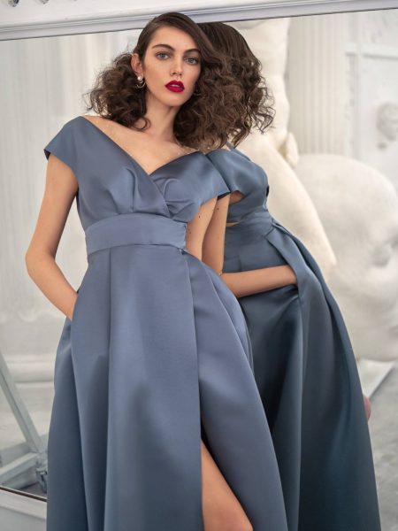 Sophistication redefined! This satin blue dress formal from the Galatea Collection stuns with its off-the-shoulder design, structured waist, and high slit—perfect for a glamorous evening.
