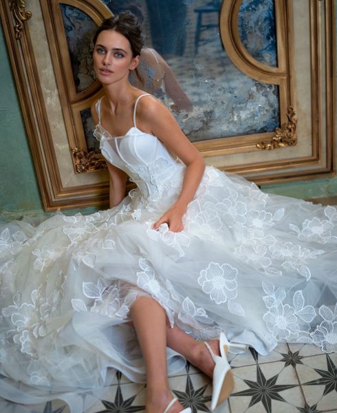 A stunning bride wearing a floral lace wedding gown with a structured bodice and delicate straps. Perfect for brides searching for Toronto sample sale wedding dresses.
