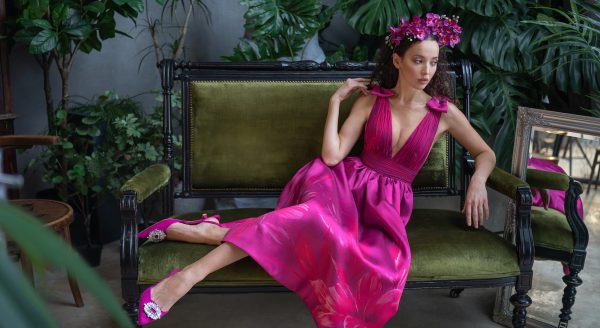 Model wearing a vibrant pink floral satin gown with a deep V-neck, showcasing elegance and sophistication, perfect for prom dresses.