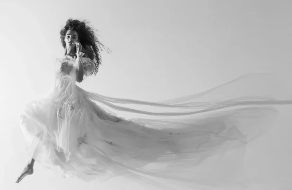 Ethereal wedding dress with flowing tulle layers, delicate floral embroidery, and an elegant silhouette, perfect for modern brides.