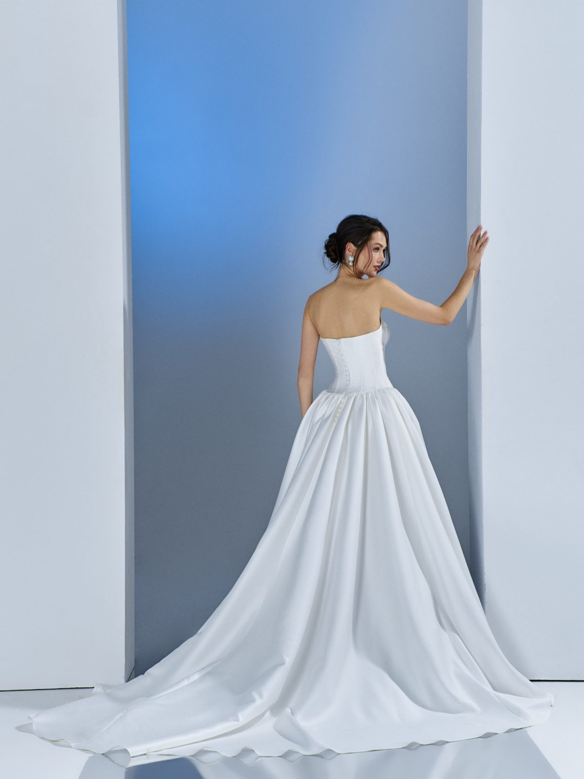 Elegant strapless satin ball gown with structured bodice and long train, showcasing timeless wedding dress trends at Papilio Boutique bridal store in Toronto.