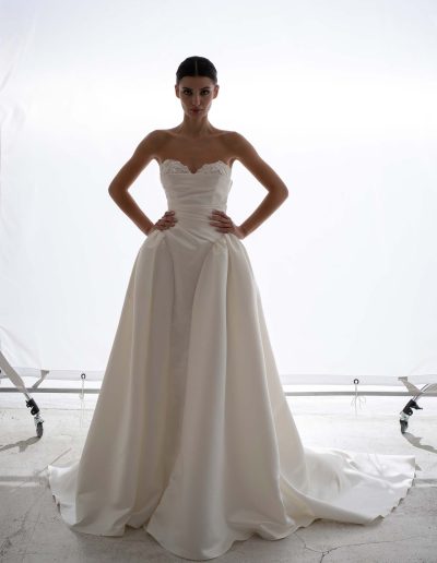 Structured satin ballgown wedding dress with cape by Papilio, close-up of lace peekaboo cups and draped satin bodice — Toronto bridal store.