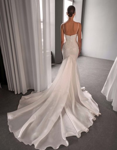 Back view of a beaded organza mermaid wedding dress with a flowing organza train, photographed at Papilio Boutique bridal store in Toronto.