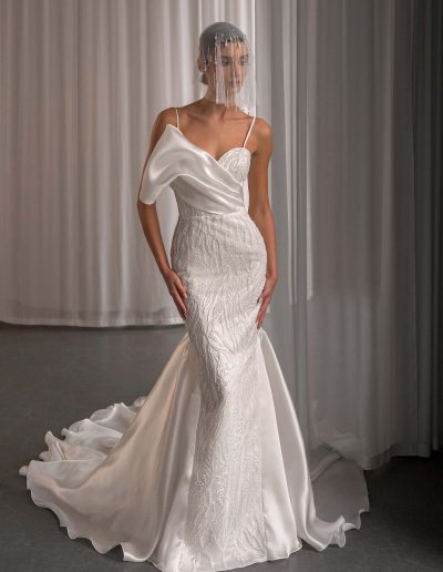 Model wearing a beaded organza mermaid wedding dress with an asymmetrical neckline, photographed at Papilio Boutique bridal store in Toronto.