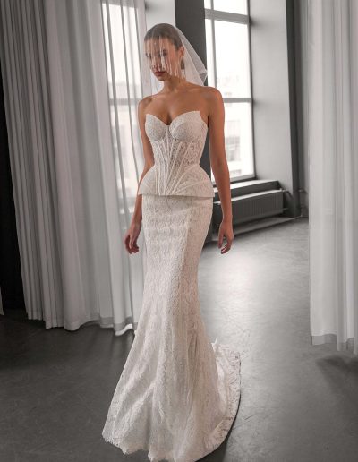 Model wearing a lace two-piece wedding dress with a semi-sheer corset and fitted lace skirt, photographed inside Papilio Boutique bridal store in Toronto.