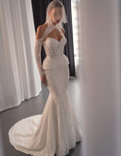 Lace two-piece wedding dress styled with a long sleeve lace bolero and halter-neck detail, shown on a model at Papilio Boutique bridal store in Toronto