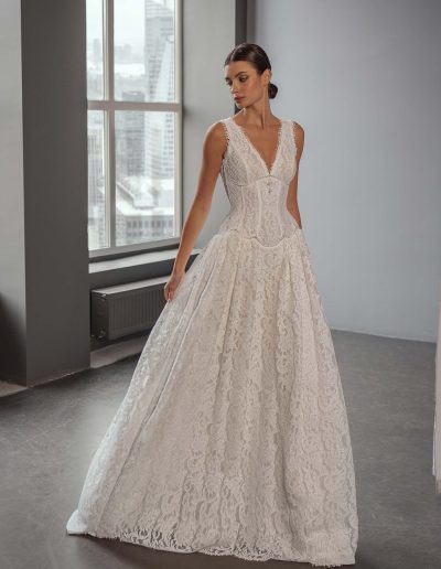 Model wearing a lace A-line wedding dress with a V-neck and beaded basque waist, photographed at Papilio Boutique bridal store in Toronto.