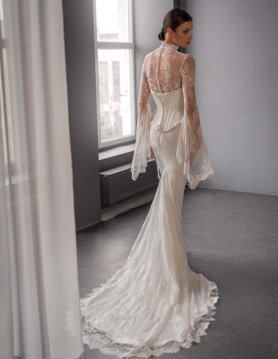 Wedding dress with bell sleeves featuring a sculpted corset and lace train by Papilio Boutique, Toronto bridal shop.