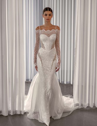 Sparkling off the shoulder wedding dress with long sleeves by Papilio Boutique, with sequins and nude-lined cutouts, from a Toronto bridal shop.