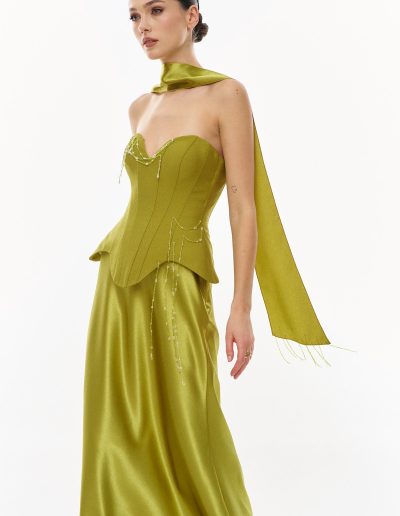 Side view of sculpted corset evening dress with flowing crepe satin skirt and long scarf detail, offered at Papilio Boutique.