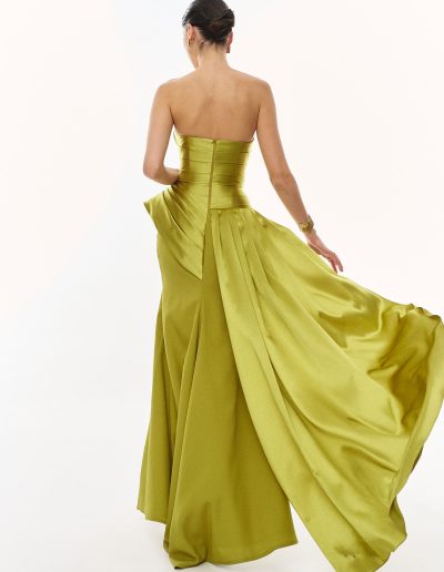 Back view in motion of strapless evening gown showing fluid pleated overskirt detail, offered at Papilio Boutique.