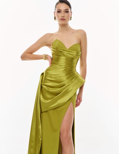 Strapless draped evening gown in motion showing flowing overskirt and thigh-high slit, offered at Papilio Boutique.
