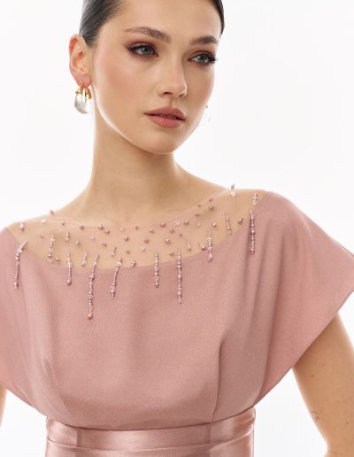 Close-up of embellished illusion neckline with crystal details on formal evening gown offered at Papilio Boutique.