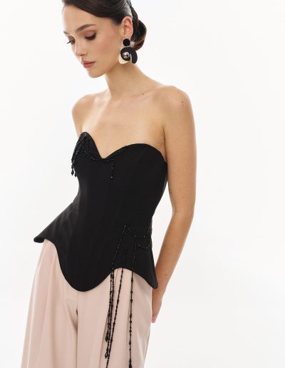 Detailed view of sculpted strapless corset with bead embellishments offered at Papilio Boutique.