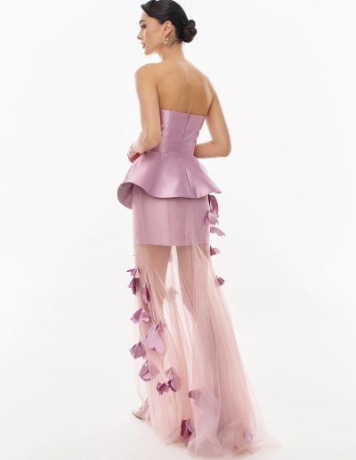Back view of peplum corset evening dress with flowing tulle overskirt offered at Papilio Boutique.